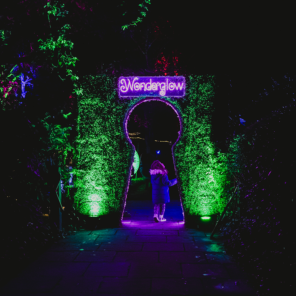young girl stood in front of key entrance to Wonderglow 
