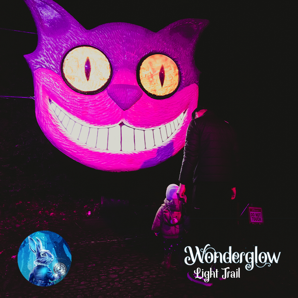 Large pink cheshire cats face with glowing eyes and wide white cheshire cat grin. paw prints are also casted on the floor